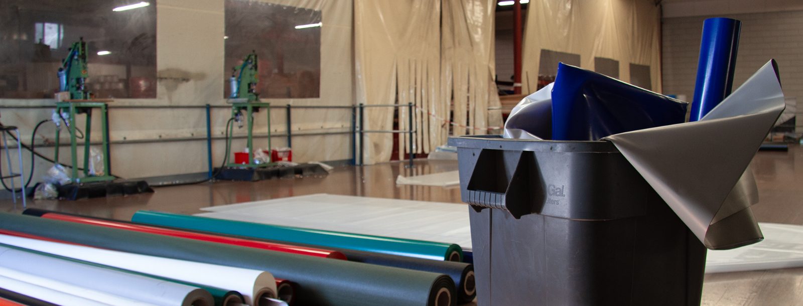 Rolls of reclaimed tarpaulin and PVC banner material at the factory