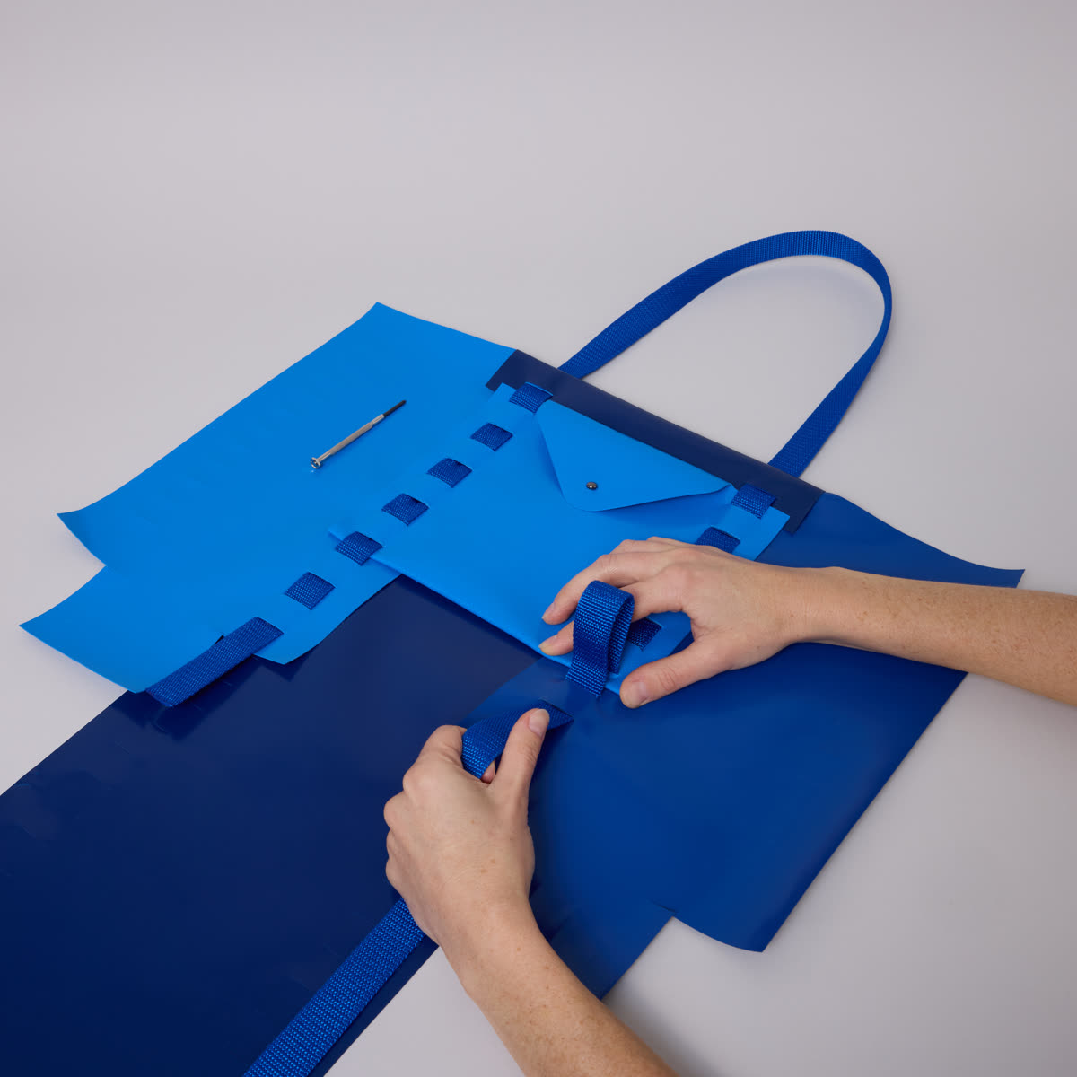 Close-up of a Tasket bag mid-assembly, panels and strap laid out